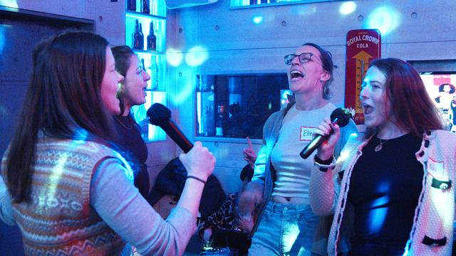 A group of guests singing together in the private karaoke room at Sing with the Stars