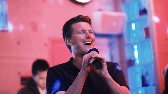 A Broadway performer singing into the mic at Sing with the Stars
