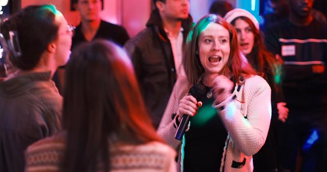 Guest singing her heart out mid-song, surrounded by a tight circle of singers joining in at RPM Underground